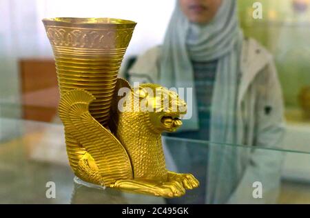 La donna musulmana iraniana ammira il leone persiano Achaemenid il vaso di Rhyton simbolo del pezzo archeologico dal V secolo a.C., Teheran, Iran Foto Stock