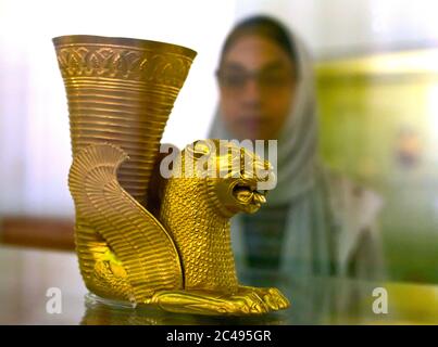 La donna musulmana iraniana ammira il leone persiano Achaemenid il vaso di Rhyton simbolo del pezzo archeologico dal V secolo a.C., Teheran, Iran Foto Stock