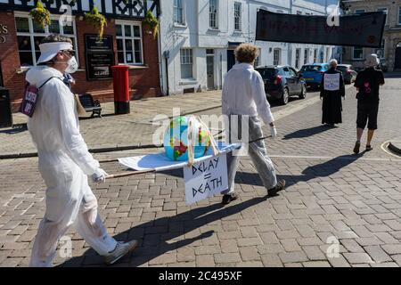 LEOMINSTER, REGNO UNITO - 25 GIUGNO 2020: I manifestanti sul cambiamento climatico si riuniscono nell'ambito di una giornata di proteste a livello nazionale con l'attenzione rivolta all'avvertimento "Delay = Death" a Leominster, Herefordshire, Regno Unito, il 25 giugno 2020. In coincidenza con la pubblicazione di un rapporto della commissione parlamentare britannica sul cambiamento climatico la sommaria processione composta da figure in costume con costumi in clessidra portava un modello bandito della terra alle porte del parlamentare locale. Credit: Jim Wood/Alamy Live News Foto Stock