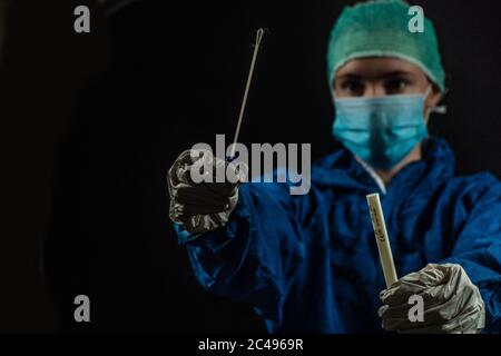 Foto stile Doomsday di tecnico medico in procinto di somministrare un test tampone Foto Stock