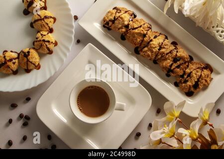 Caffè con latte e biscotti. Biscotti rotondi senza glutine a base di farina di riso. Su sfondo bianco, vista dall'alto. Foto Stock