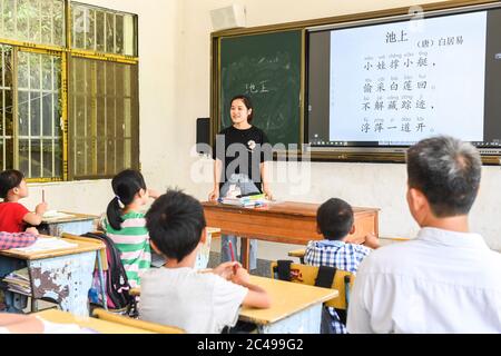 (200625) -- NINGMING, 25 giugno 2020 (Xinhua) -- Jiao Lingxia dà una lezione ad un luogo di insegnamento in città di Aidian della contea di Ningming, regione autonoma di Guangxi Zhuang della Cina meridionale, 23 giugno 2020. Jiao Shengding, 52 anni, è l'unico insegnante del villaggio di Zhangji, situato al confine tra Cina e Vietnam. Dopo essersi laureato alla scuola professionale secondaria della contea nel 1990, Jiao ha scelto di essere un insegnante presso il suo villaggio di Zhangji, città natale, e da allora ha insegnato lì per 30 anni. Negli ultimi tre decenni ha insegnato più di 400 alunni, la maggior parte dei quali Foto Stock