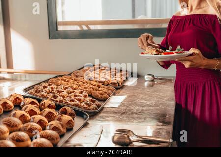 donne intorno al tavolo durante il brunch a buffet con le mani, mettendo i cibi sul piatto. Ristorazione buffet Ristorazione pranzo cena Party Sharing concetto. Ristorante Foto Stock