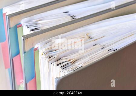 Closeup di leganti con carta e linguette. Pila di documenti aziendali, fatture o documenti in raccoglitori di documenti in piedi. Concetto di vita senza debito. Foto Stock