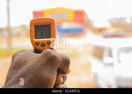 Termometro elettronico nelle mani di una persona utilizzato per misurare il corpo temperatura Foto Stock