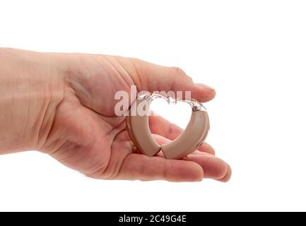 La mano forma un cuore dagli apparecchi acustici BTE (dietro l'orecchio). Studio isolato su bianco. Foto Stock