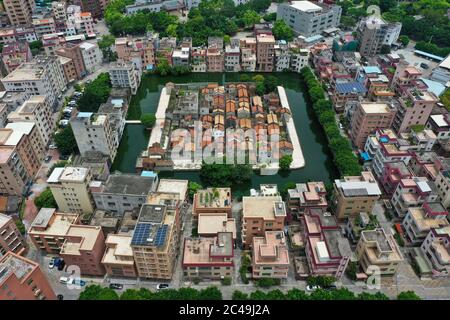 Dongguan. 24 Giugno 2020. Foto aerea scattata il 24 giugno 2020 mostra la Fortezza del villaggio di Nishui Liugui nella cittadina di Humen della città di Dongguan, nella provincia di Guangdong, nella Cina meridionale. Nishui Liugui Village Fortezza, un villaggio a forma di tartaruga che un tempo funzionava come una fortezza militare, ha una storia di più di 370 anni. Coprendo un'area di 6,889 metri quadrati e circondato da un fossato largo 18 metri, il villaggio dall'aria sembra una tartaruga che nuotano a monte. Credit: Liu Dawei/Xinhua/Alamy Live News Foto Stock