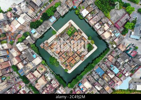 Dongguan. 24 Giugno 2020. Foto aerea scattata il 24 giugno 2020 mostra la Fortezza del villaggio di Nishui Liugui nella cittadina di Humen della città di Dongguan, nella provincia di Guangdong, nella Cina meridionale. Nishui Liugui Village Fortezza, un villaggio a forma di tartaruga che un tempo funzionava come una fortezza militare, ha una storia di più di 370 anni. Coprendo un'area di 6,889 metri quadrati e circondato da un fossato largo 18 metri, il villaggio dall'aria sembra una tartaruga che nuotano a monte. Credit: Liu Dawei/Xinhua/Alamy Live News Foto Stock