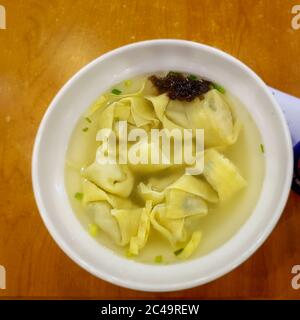 Zuppa di Wonton - Wonton, un tipo di gnocchi cinesi ripieni di carne tritata, di solito maiale e borsetta di pastore serviti in zuppa di pollo. Cibo locale. Foto Stock