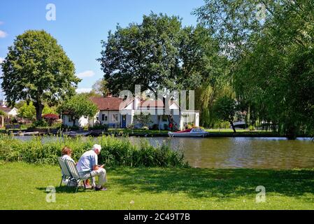 Una coppia anziana si rilassa mentre si siede sul fiume in una calda giornata estiva a Shepperton Surrey UK Foto Stock