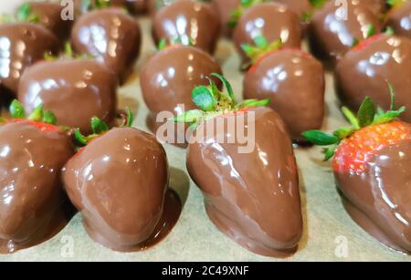 fragole dolci immerse nel cioccolato e pronte a mangiare Foto Stock