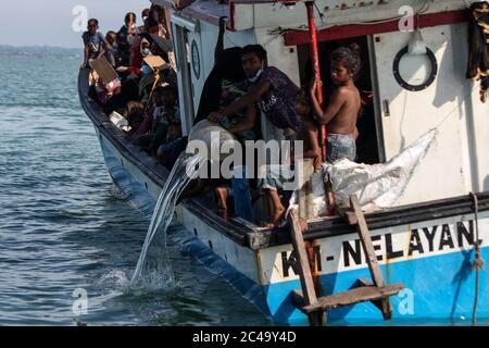 Aceh Utara, Indonesia. 25 Giugno 2020. Un giovane Rohingya è visto che attinge acqua dal boatAccording di legno ai funzionari locali, fino a 94 Rohingyas sono stati trovati dai pescatori Acehnesi bloccati nel mezzo delle acque del mare 1 chilometro dalla costa al largo della provincia di Aceh utilizzando barche di legno. Credit: SOPA Images Limited/Alamy Live News Foto Stock