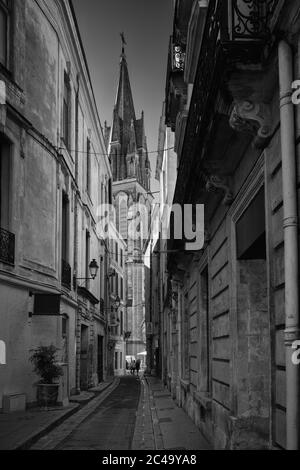 Vicoli stretti e ombreggiati nel centro storico di Montpellier invitano le persone a fare una passeggiata. Sullo sfondo è visibile la torre di San Rocco. Foto Stock