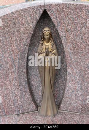 Sint Gillis WAAS, Belgio, 9 luglio 2019, la statua di rame chiaro in una nicchia di marmo rappresenta la Vergine Maria in preghiera Foto Stock