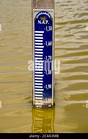 Palo con indicatore del livello dell'acqua in un canale olandese che indica che l'acqua è a due metri sotto il livello del mare Foto Stock