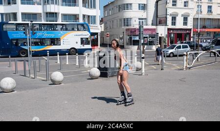 Worthing UK 25 Giugno 2020 - UNA giovane donna rullo lame come lei gode le condizioni di onda di calore sul lungomare di Worthing oggi come temperature raggiungere oltre 30 gradi in alcune parti del Sud Est di oggi: Credit Simon Dack / Alamy Live News Foto Stock