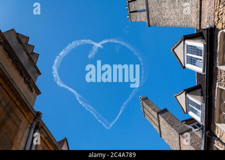 Cambridge, Regno Unito. 25 Giugno 2020. Scrittura di segnali aerei o skywriting - un aereo attira un cuore in un sentiero di fumo bianco sopra gli edifici storici della Cambridge University nel cielo blu. Amore Cambridge! Credit: Julian Eales/Alamy Live News Foto Stock