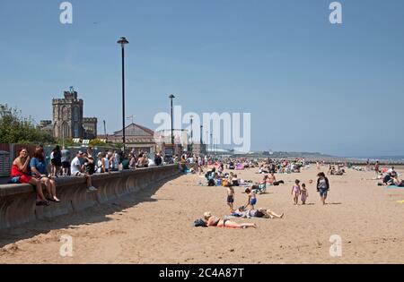 Portobello, Edimburgo, Scozia, Regno Unito. 25 giugno 2020. 2° giorno di tempo molto caldo anche se più fresco per iniziare con una brezza fresca come ha cominciato a riscaldare vapore ha cominciato a salire dalla sabbia bagnata causando una foschia, temperatura ha raggiunto 20 gradi all'ora di pranzo, più persone fuori prima di là erano ieri, Luppolyusing schermo solare per proteggerli dai raggi UV più alti che gli agenti atmosferici stanno avvertendo circa. Foto Stock