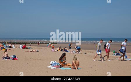 Portobello, Edimburgo, Scozia, Regno Unito. 25 giugno 2020. 2° giorno di tempo molto caldo anche se più fresco per iniziare con una brezza fresca come ha cominciato a riscaldare vapore ha cominciato a salire dalla sabbia bagnata causando una foschia, temperatura ha raggiunto 20 gradi all'ora di pranzo, più persone fuori prima di là erano ieri, Luppolyusing schermo solare per proteggerli dai raggi UV più alti che gli agenti atmosferici stanno avvertendo circa. Foto Stock