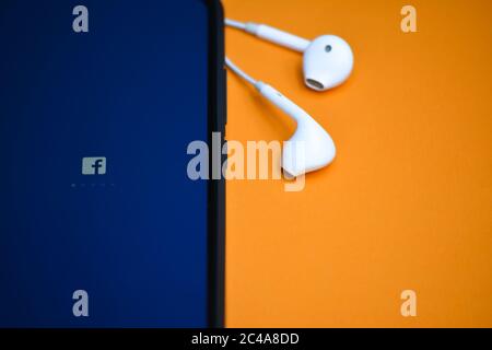 TIKAMGARH, MADHYA PRADESH, INDIA - 17 DICEMBRE 2019: Caricamento delle applicazioni Facebook sullo schermo del telefono cellulare con auricolari. Foto Stock