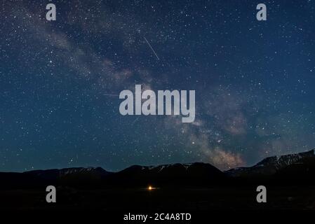 Panorama notturno del cielo stellato con la galassia della Via Lattea, stelle, nebulose e meteore, sparato in un'ora blu in montagna Foto Stock
