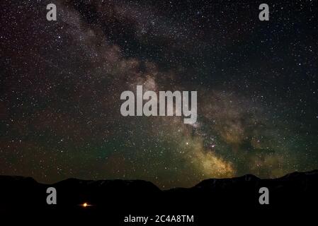 Panorama notturno del cielo stellato con la galassia della Via Lattea, stelle, nebulose e meteore in montagna Foto Stock