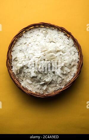 Riso crudo appiattito o fiocchi di riso spesso o sottili per spuntini Namkeen Chivda o Aloo POHA per colazione Indiana, serviti in una ciotola Foto Stock