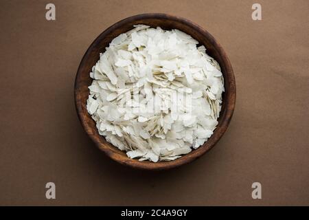 Riso crudo appiattito o fiocchi di riso spesso o sottili per spuntini Namkeen Chivda o Aloo POHA per colazione Indiana, serviti in una ciotola Foto Stock