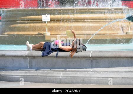 Londra, UK 25 Giugno 2020 relax sulla Fountain.Sun in Trafalgar Square il giorno più caldo dell'anno. Credit: JOHNNY ARMSTEAD/Alamy Live News Foto Stock