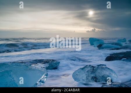 La spiaggia di Jokulsarlon, nota anche come spiaggia di diamanti, si trova al largo della A1 Coast Road sulla costa. Iceberg - alcuni sono grandi blocchi - riflettono la luce contro un insieme di sabbia nera. Foto Stock