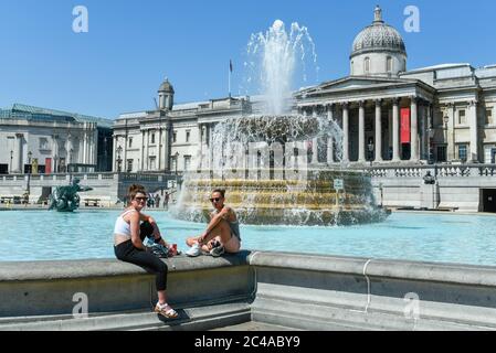 Londra, Regno Unito. 25 giugno 2020. Regno Unito Meteo: I turisti godono del sole in Trafalgar Square, su quello che si prevede sia il giorno più caldo dell'anno finora. L'indice UV dell'Ufficio MET dovrebbe raggiungere livelli eccezionalmente elevati, a causa di cielo limpido e dell'assenza di percorsi per il vapore degli aeromobili a causa di una riduzione dei voli durante la pandemia del coronavirus. Credit: Stephen Chung / Alamy Live News Foto Stock