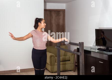 Una ragazza adolescente si appoggia contro un bar mentre si pratica balletto a casa Foto Stock