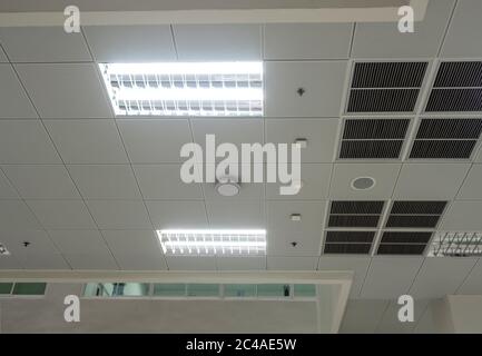 Maschera di climatizzazione, illuminazione e moderne attrezzature sul soffitto, spegnimento selezionato alcune luci per il risparmio energetico Foto Stock