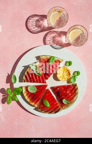 fette di anguria grigliate con limone e basilico. dessert estivo Foto Stock