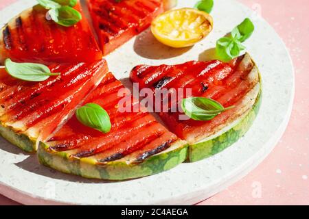 fette di anguria grigliate con limone e basilico. dessert estivo Foto Stock