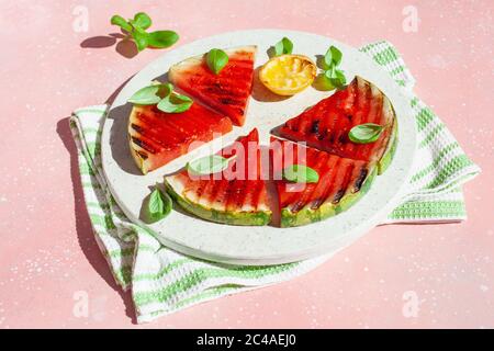 fette di anguria grigliate con limone e basilico. dessert estivo Foto Stock
