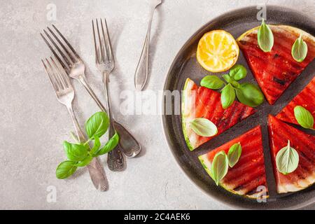 fette di anguria grigliate con limone e basilico. dessert estivo Foto Stock
