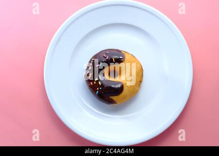 vista dall'alto dell'angelo sulle ciambelle di cioccolato sul piatto Foto Stock