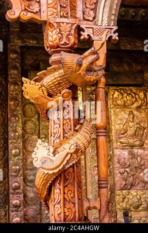 Un drago a spirale intagliato sulla colonna di legno della porta di un antico tempio indù nel villaggio di Kalpa a Kinnaur, India. Foto Stock