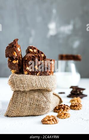 Biscotti al cioccolato fatti in casa con noci e un bicchiere di latte Foto Stock