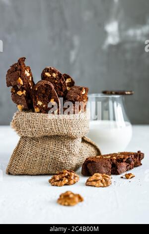 Biscotti al cioccolato fatti in casa con noci e un bicchiere di latte Foto Stock