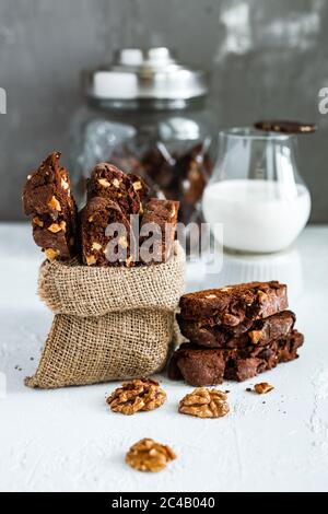 Biscotti al cioccolato fatti in casa con noci e un bicchiere di latte Foto Stock