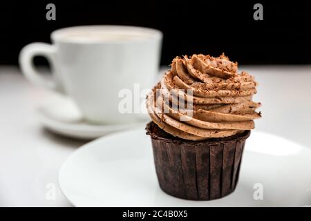 Una deliziosa torta al cioccolato con crema e una tazza di cappuccino Foto Stock