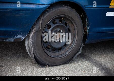 Kiev, Ucraina - 21 giugno 2020: Ruota di una vettura con un vecchio pneumatico. Pneumatico obsoleto danneggiato. Strappato e pieno di fori. Montaggio pneumatici, primo piano. Spazio di copia. Foto Stock