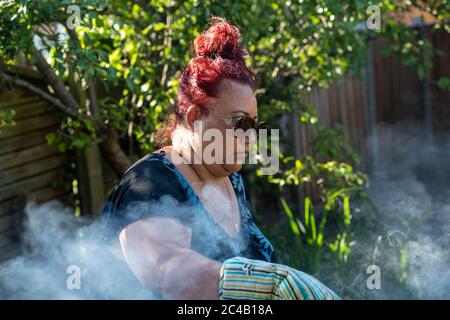 Brentwood Essex 25 giugno 2020 METEO Mary-Jane Davidson, infermiera NHS, prepara un barbecue estivo nel giardino Brentwood Essex Credit: Ian Davidson/Alamy Live News Foto Stock