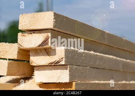 un mucchio di circa segato, tagliare lunghe barre di legno, tavole, si trovano all'aperto sulla strada sfondo il cielo Foto Stock