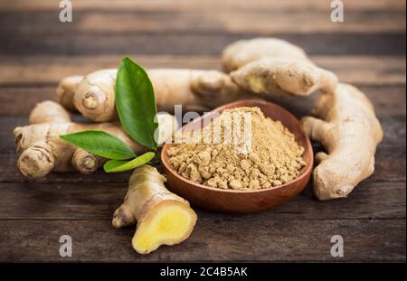 Radice di zenzero e polvere di zenzero nel recipiente Foto Stock