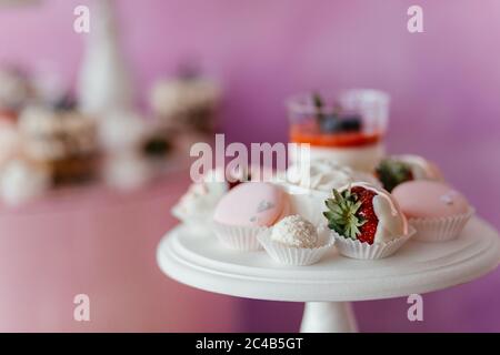 Tavolo da dessert con panna cotta, meringhe e fragola in cioccolato bianco. Dessert. Tavolo da dessert Foto Stock