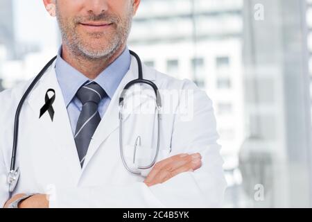 Metà sezione del medico maschile con nastro nero su accappatoio in ospedale Foto Stock