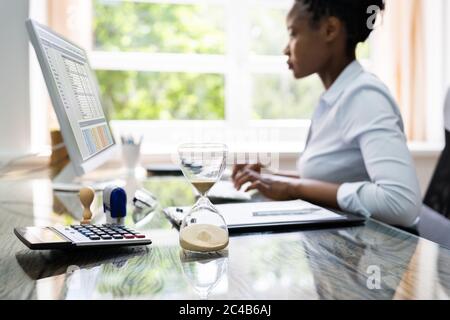 Black Accountant Woman lavora con fattura e clessidra Foto Stock